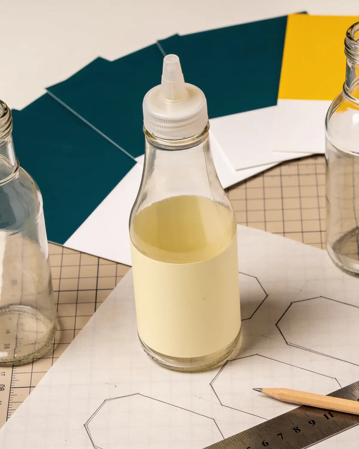 A packaging designer's desk with blank bottles and color swatches